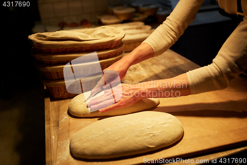 Image of chef or baker with dough cooking bread at bakery