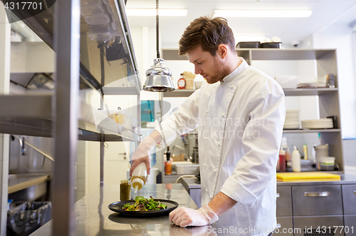 Image of happy male chef cooking food at restaurant kitchen