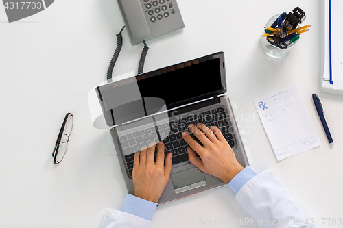 Image of doctor hands typing on laptop at clinic