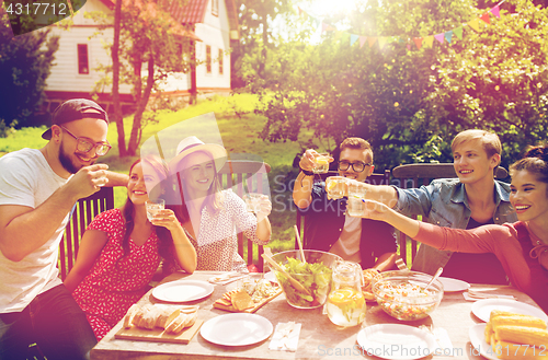 Image of happy friends having party at summer garden