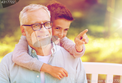 Image of grandfather and boy pointing finger at summer park