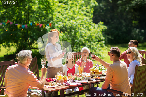 Image of happy family having dinner or summer garden party