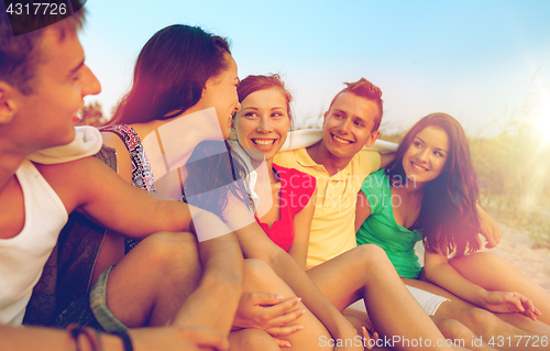 Image of smiling friends in sunglasses on summer beach