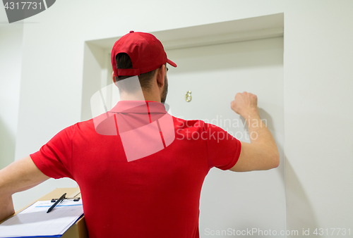 Image of delivery man with parcel box knocking door