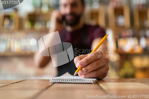 Image of bartender with notebook and pencil at bar