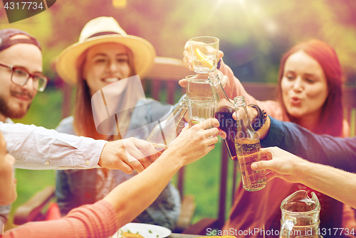 Image of happy friends with drinks at summer garden party