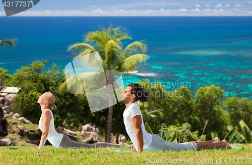 Image of couple making yoga cobra pose outdoors