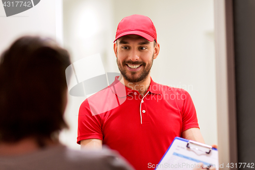 Image of deliveryman with clipboard at customer home