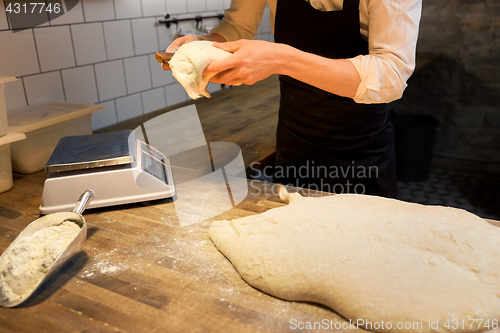 Image of baker portioning dough with bench cutter at bakery