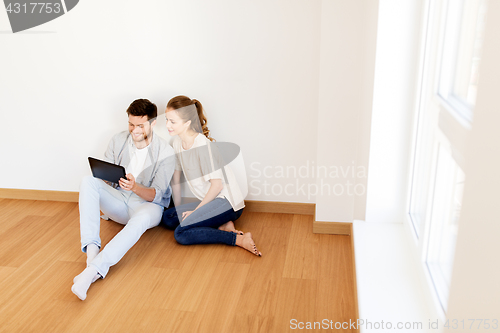 Image of happy couple with tablet pc computer at new home