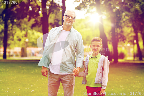 Image of grandfather and grandson walking at summer park