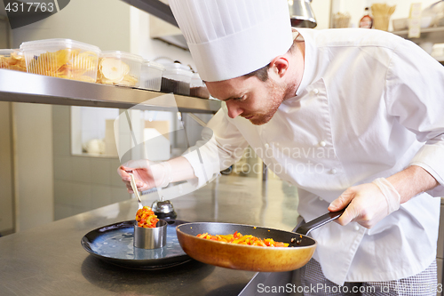 Image of happy male chef cooking food at restaurant kitchen