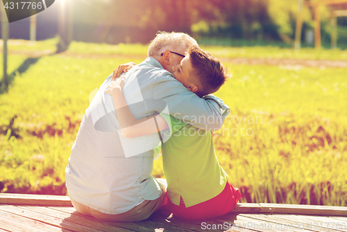 Image of grandfather and grandson hugging on berth