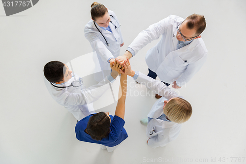 Image of group of doctors making high five at hospital
