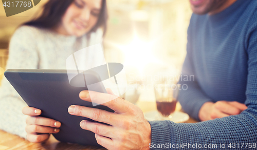 Image of happy couple with tablet pc drinking tea at cafe
