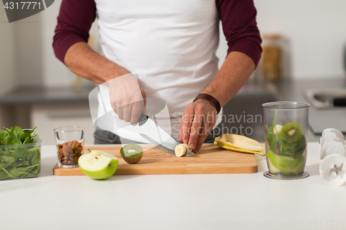 Image of man with blender and fruit cooking at home kitchen