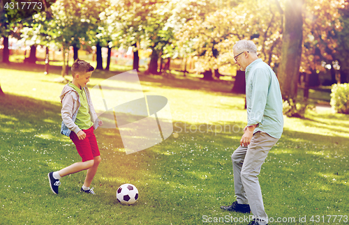 Image of old man and boy playing football at summer park