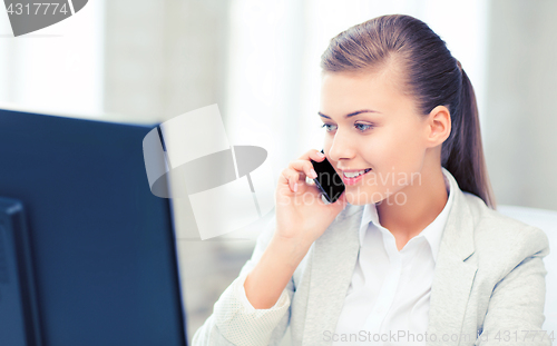 Image of businesswoman with smartphone in office