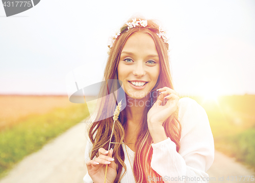 Image of smiling young hippie woman on cereal field