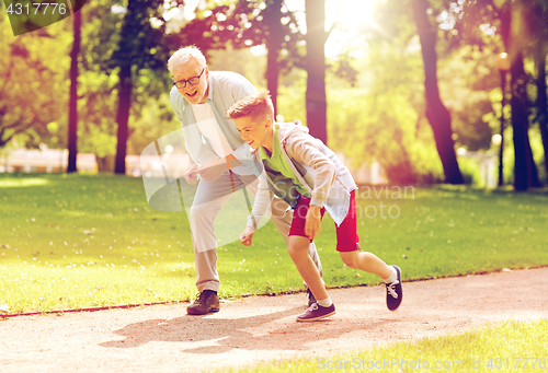 Image of grandfather and grandson racing at summer park