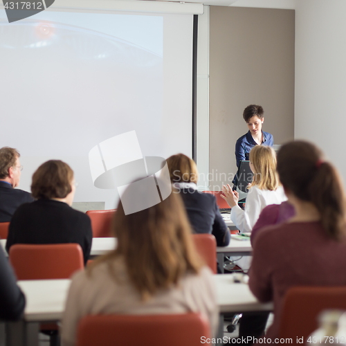 Image of Woman giving presentation in lecture hall at university.