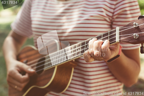 Image of Anonymous woman playing ukulele