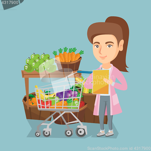 Image of Young caucasian woman checking a shopping list.