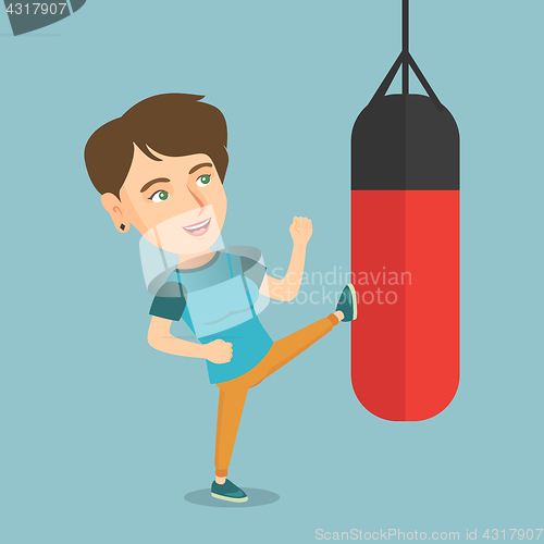 Image of Young caucasian woman exercising with punching bag