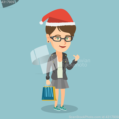 Image of Woman in santa hat shopping for christmas gifts.