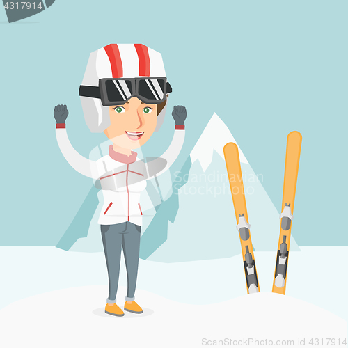 Image of Young caucasian skier standing with raised hands.