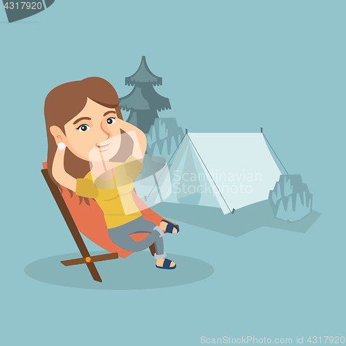 Image of Woman sitting in a folding chair in the camping.