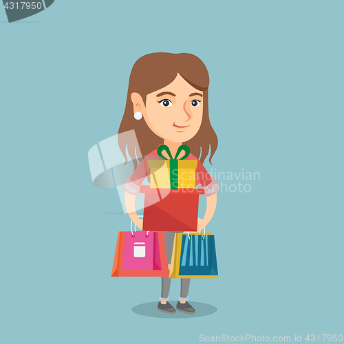 Image of Young woman holding shopping bags and gift boxes.