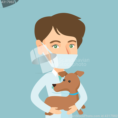 Image of Young caucasian veterinarian with dog in hands.
