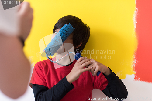 Image of young boy painter with paint roller