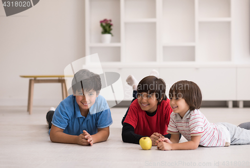 Image of boys having fun with an apple on the floor