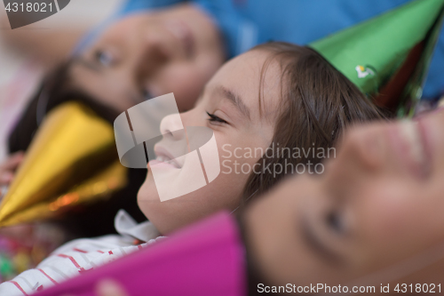 Image of kids  blowing confetti while lying on the floor