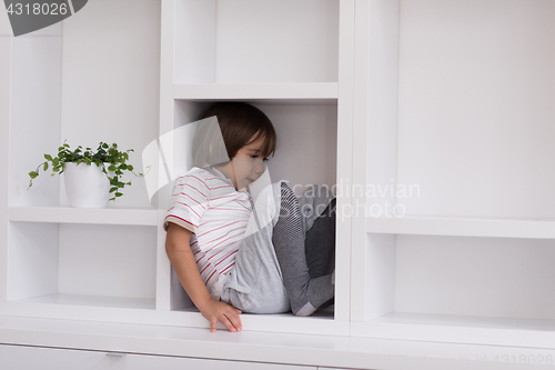 Image of young boy posing on a shelf