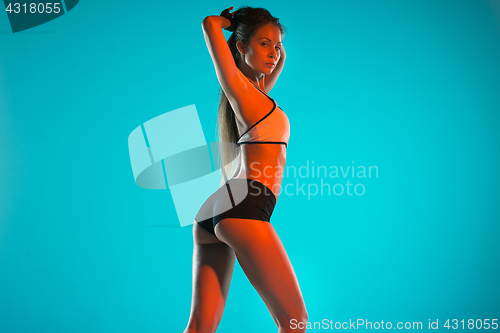 Image of Muscular young woman athlete posing at studio