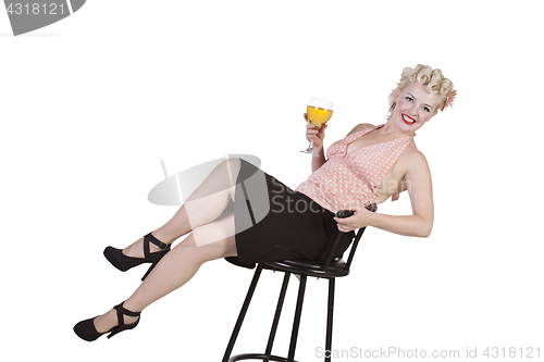 Image of Woman in pin-up dress drinking on a chair - Isolated