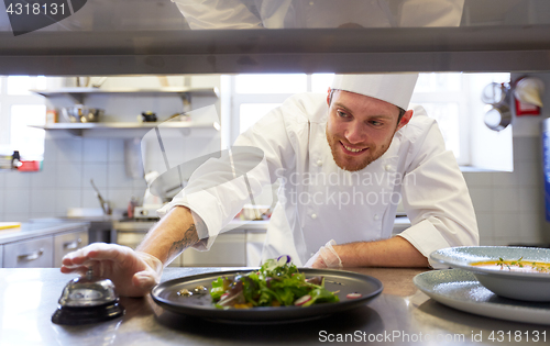 Image of happy male chef cooking food at restaurant kitchen