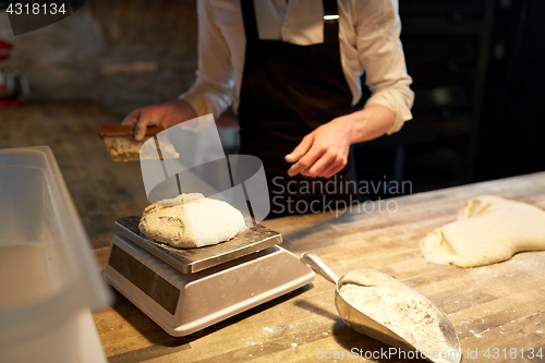 Image of chef or baker weighing dough on scale at bakery