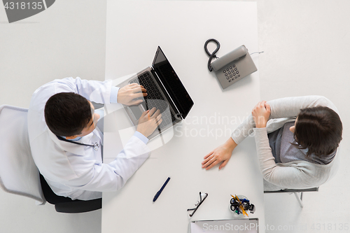 Image of doctor with laptop and woman patient at hospital