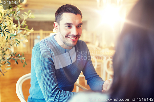 Image of happy couple talking at cafe or restaurant