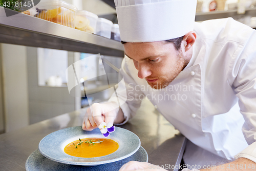 Image of happy male chef cooking food at restaurant kitchen