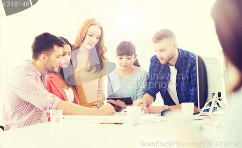 Image of creative team with papers an tablet pc at office
