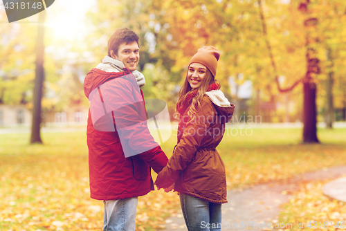 Image of happy young couple walking in autumn park