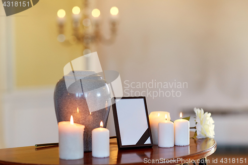 Image of photo frame, cremation urn and candles in church