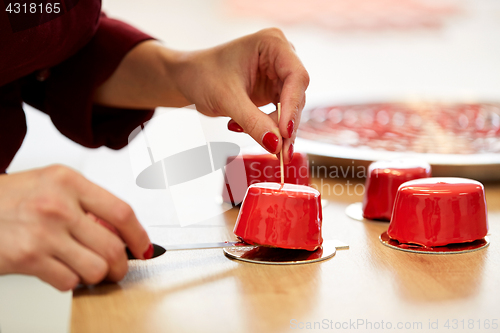 Image of chef serving mirror glaze cakes at pastry shop