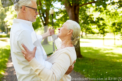 Image of happy senior couple dancing at summer city park