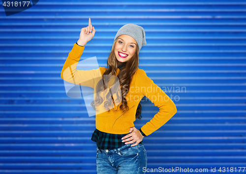 Image of happy young woman or teen girl pointing finger up